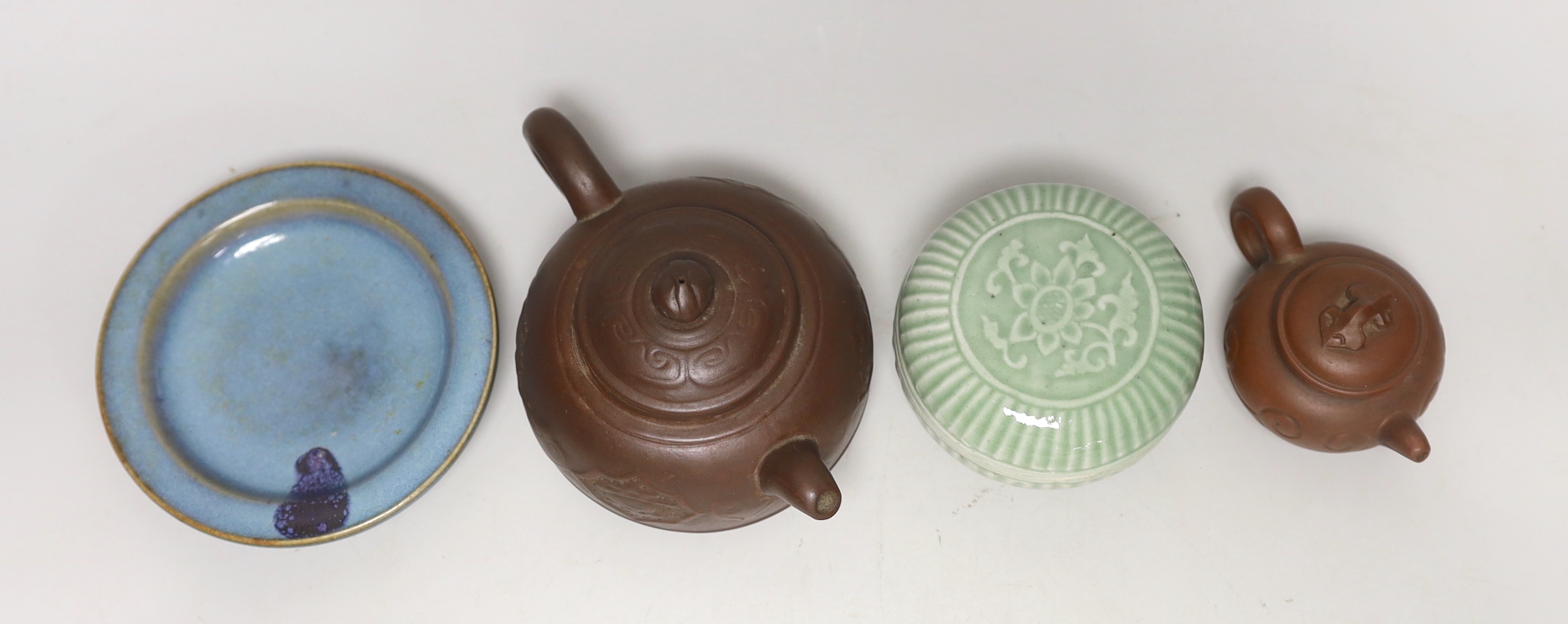 Two Yixing teapots, a celadon glazed circular box and Jun type saucer, 12cm diameter